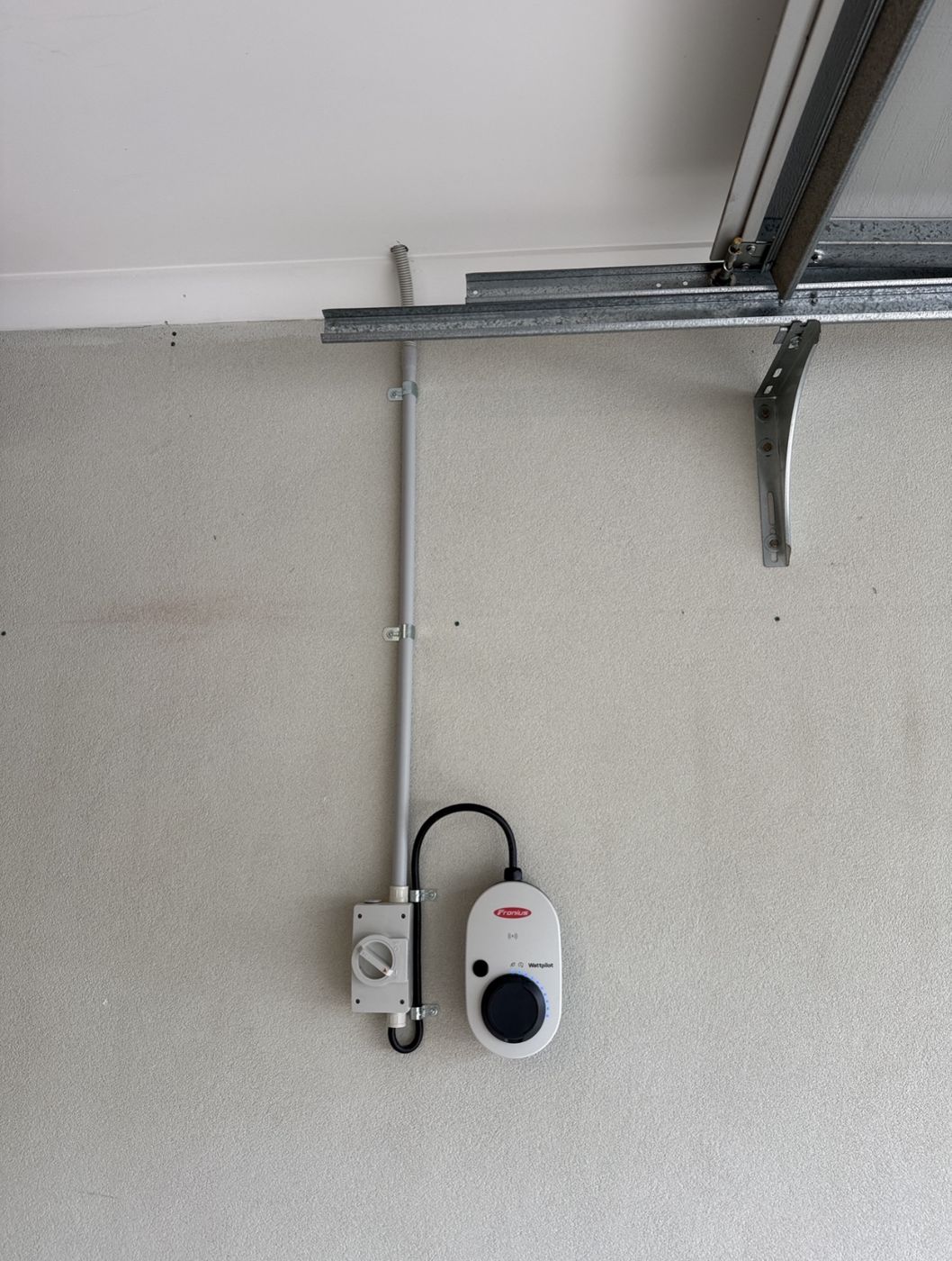 Fronius Wattpilot EV charger with isolator and surface conduit in a garage
