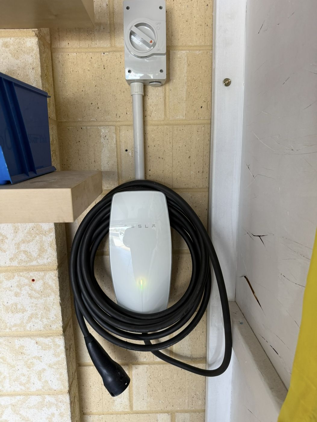 Tesla Wall Connector with a rotary isolator mounted above in a Perth garage