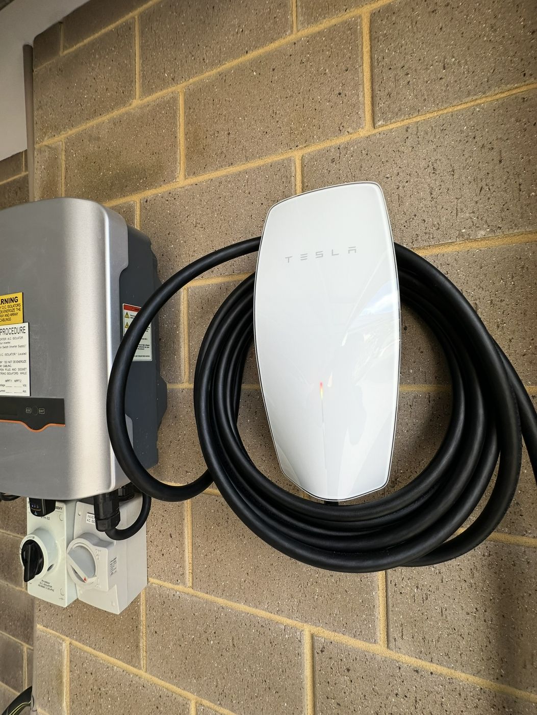 Tesla Wall Connector installed beside a solar inverter in a Perth garage