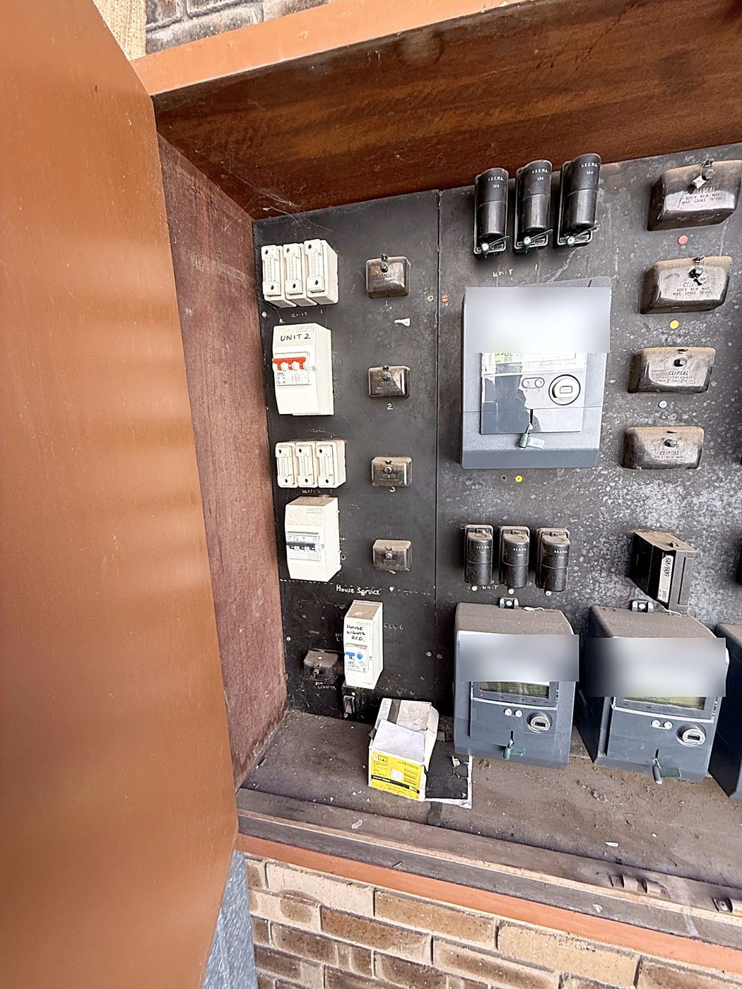 Old meter board for a block of units with fuses, meters and circuit breakers