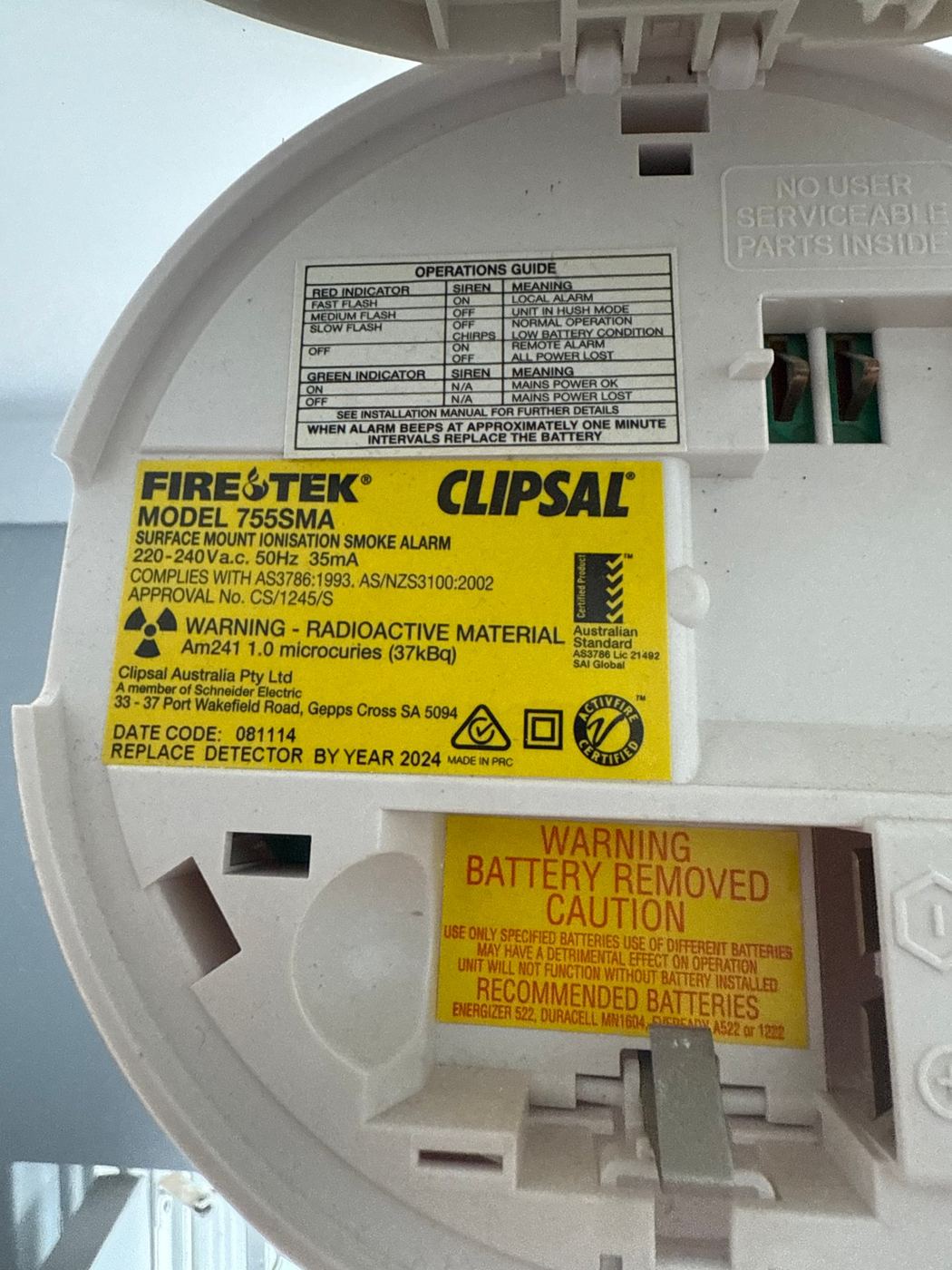 Back of an old Clipsal ionisation smoke alarm labelled replace detector by year 2024