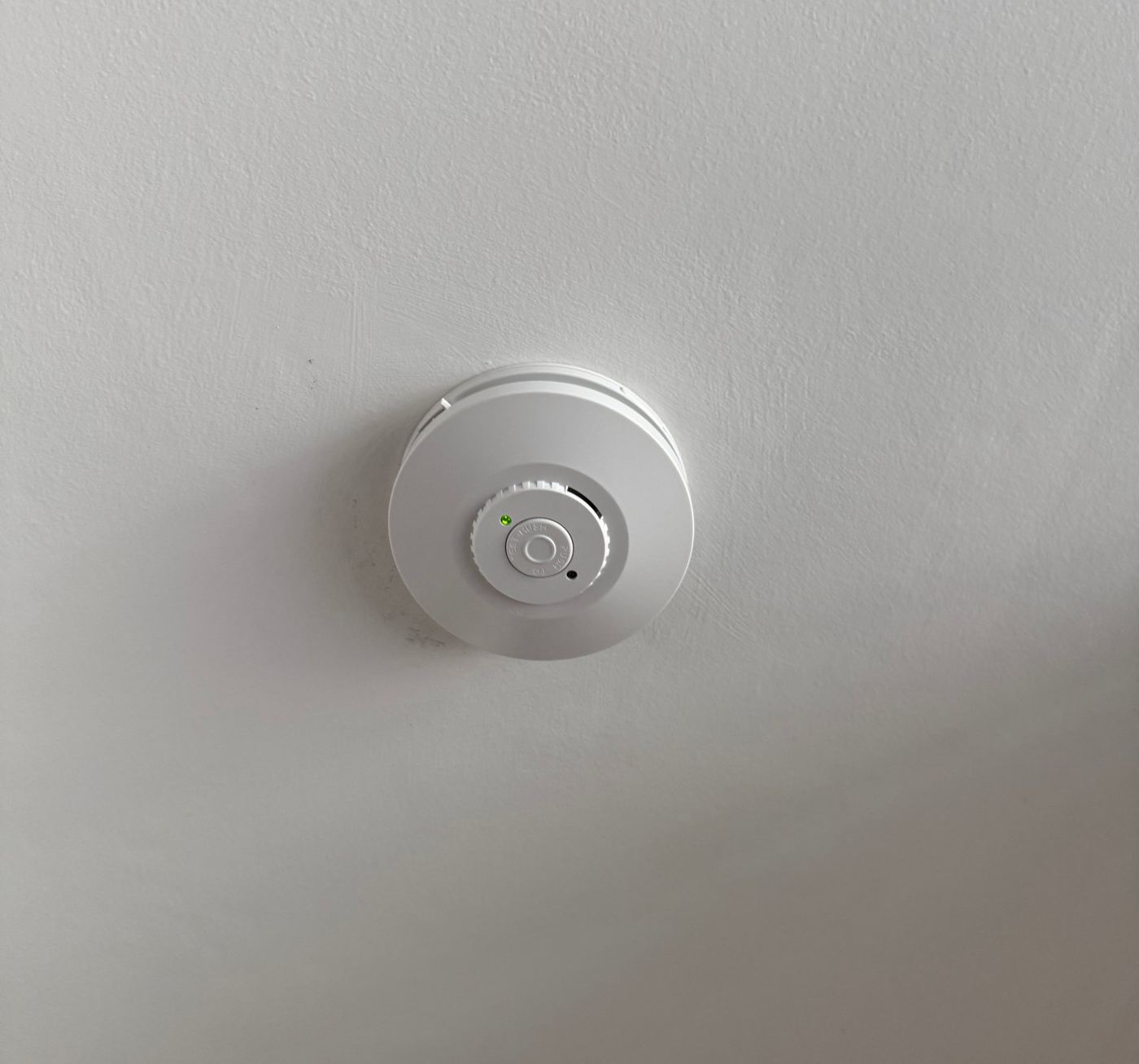 New hard-wired smoke alarm installed on a ceiling