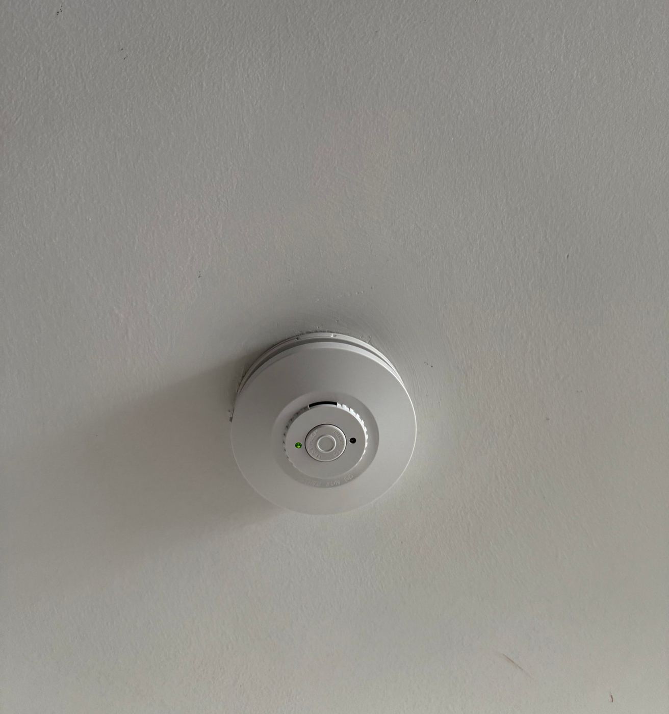Replacement hard-wired smoke alarm on a ceiling